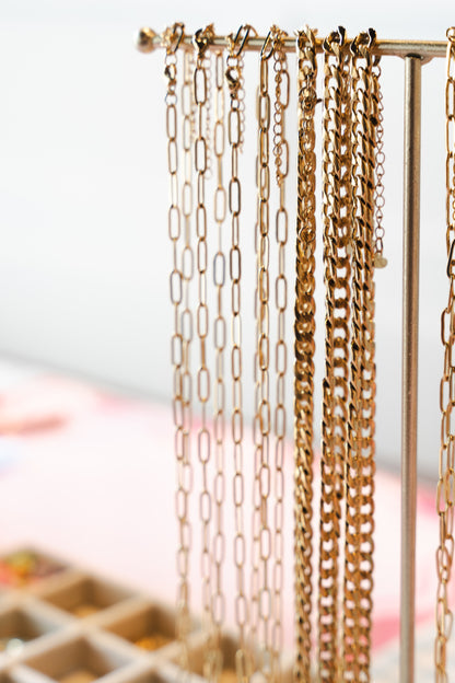 Persona sosteniendo collares con charms personalizados en taller de joyas artesanales originales